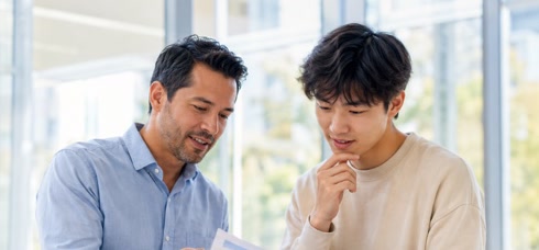 A mentor reviewing a portfolio with a young professional