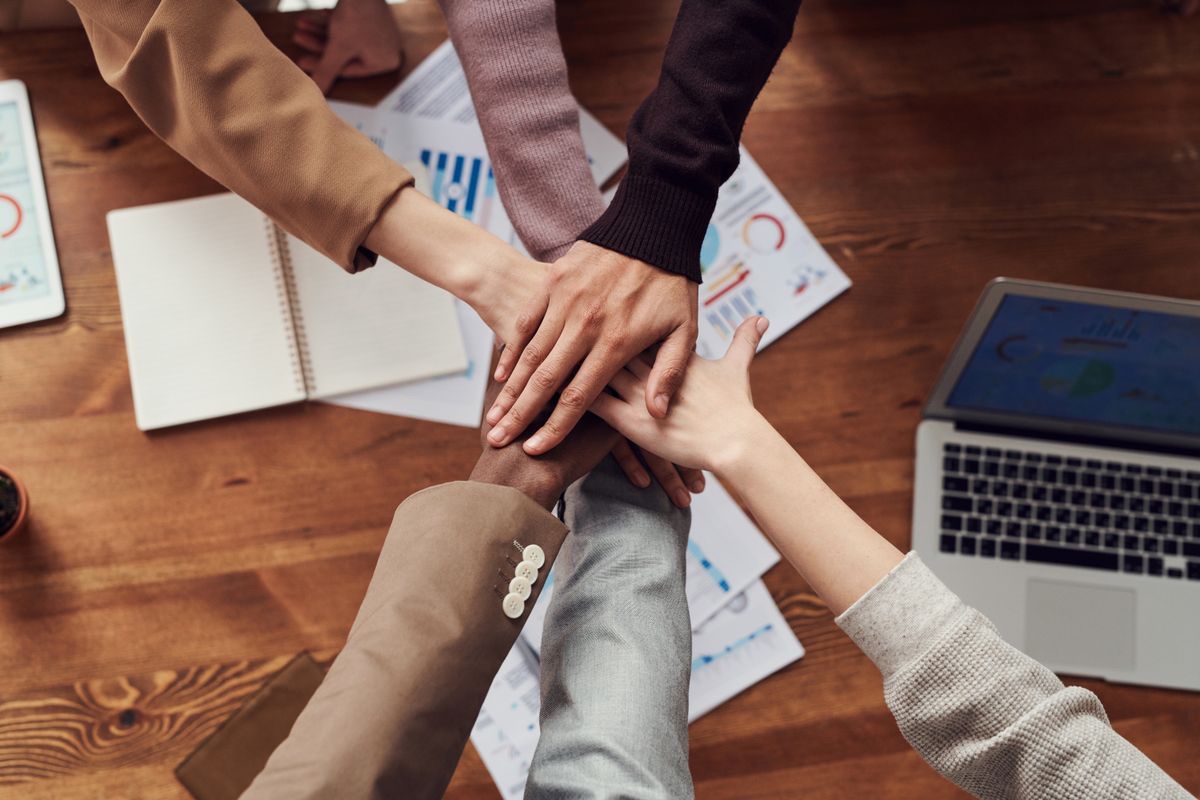 A team stacking hands together over a work table