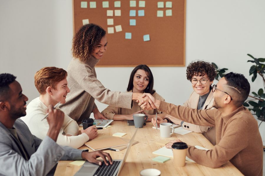 A mentor and mentee shaking hands over a planning table